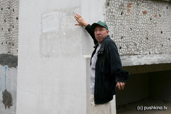 Местный житель демонстрирует стену дома
